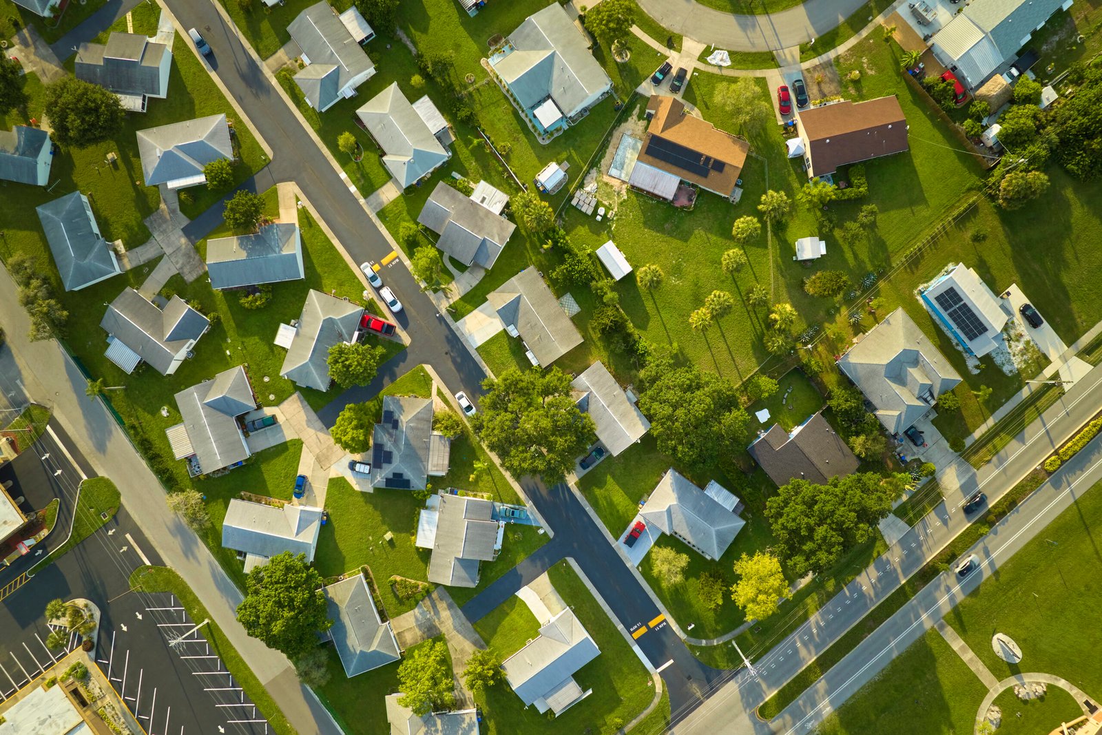 Aerial landscape view of suburban private houses between green palm trees in Florida quiet rural area.